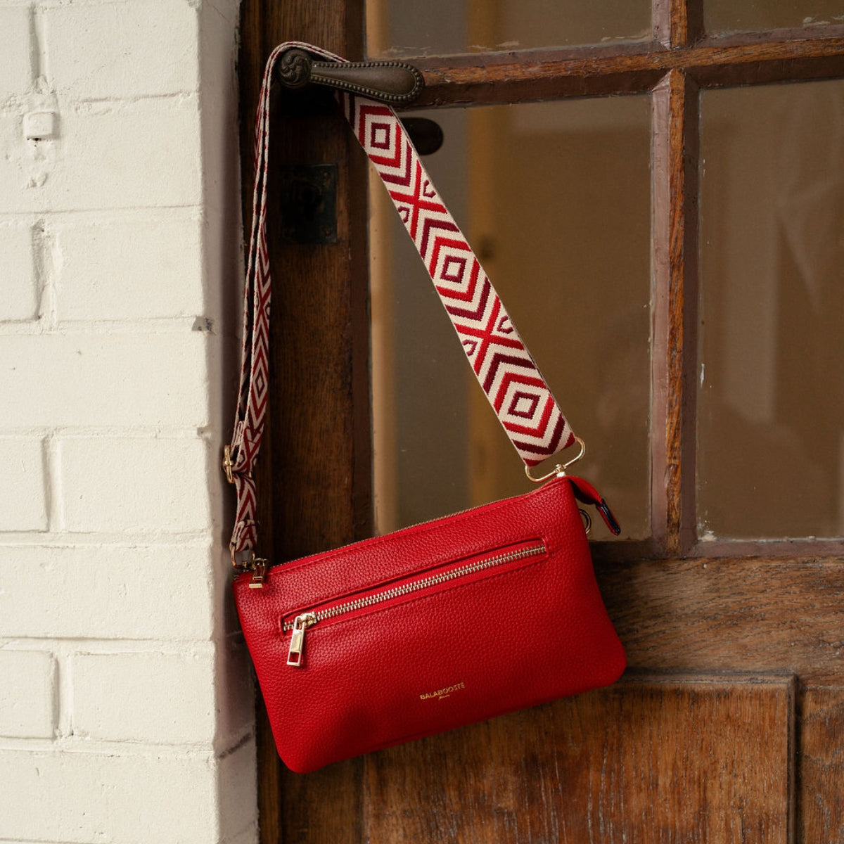 Pochette rouge multi‑poches avec bandoulière motif géométrique