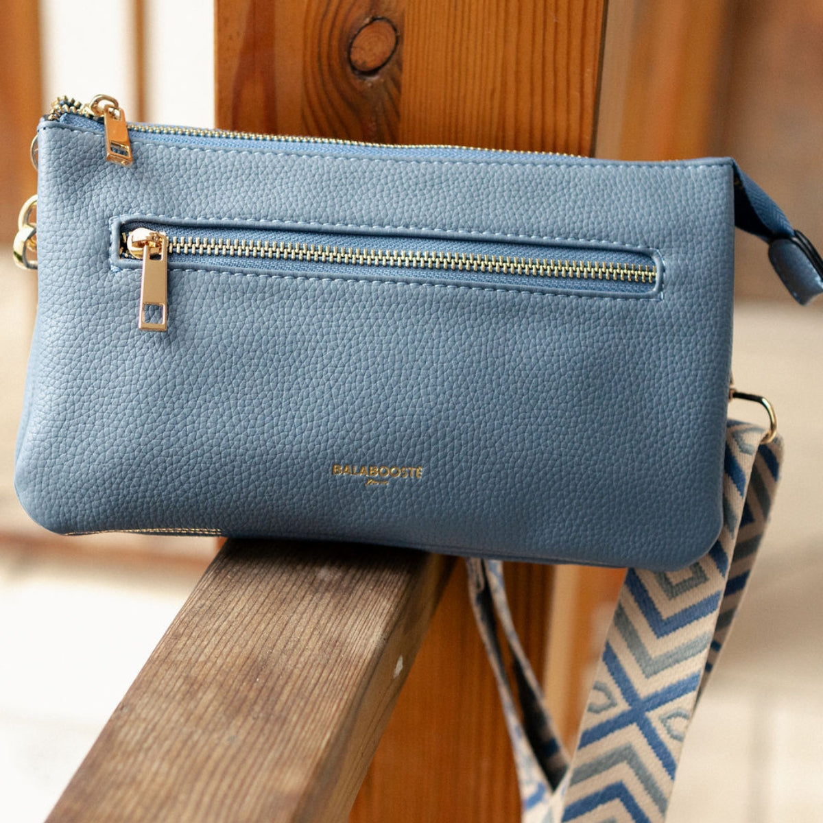 Pochette bleue multi‑poches avec bandoulière motif géométrique