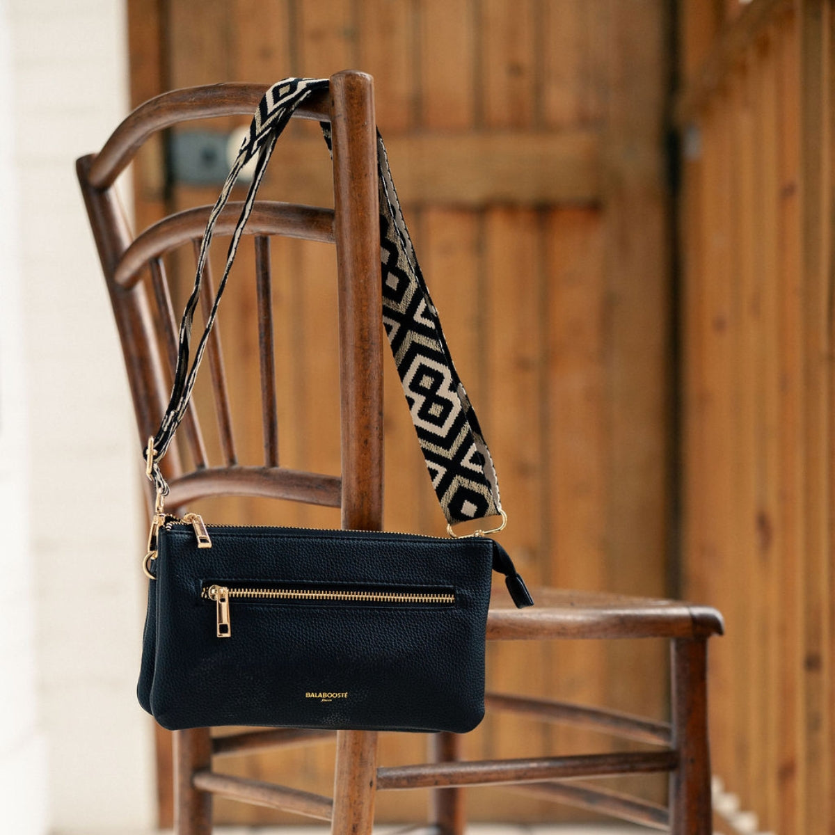 Pochette noire multi‑poches avec bandoulière motif géométrique